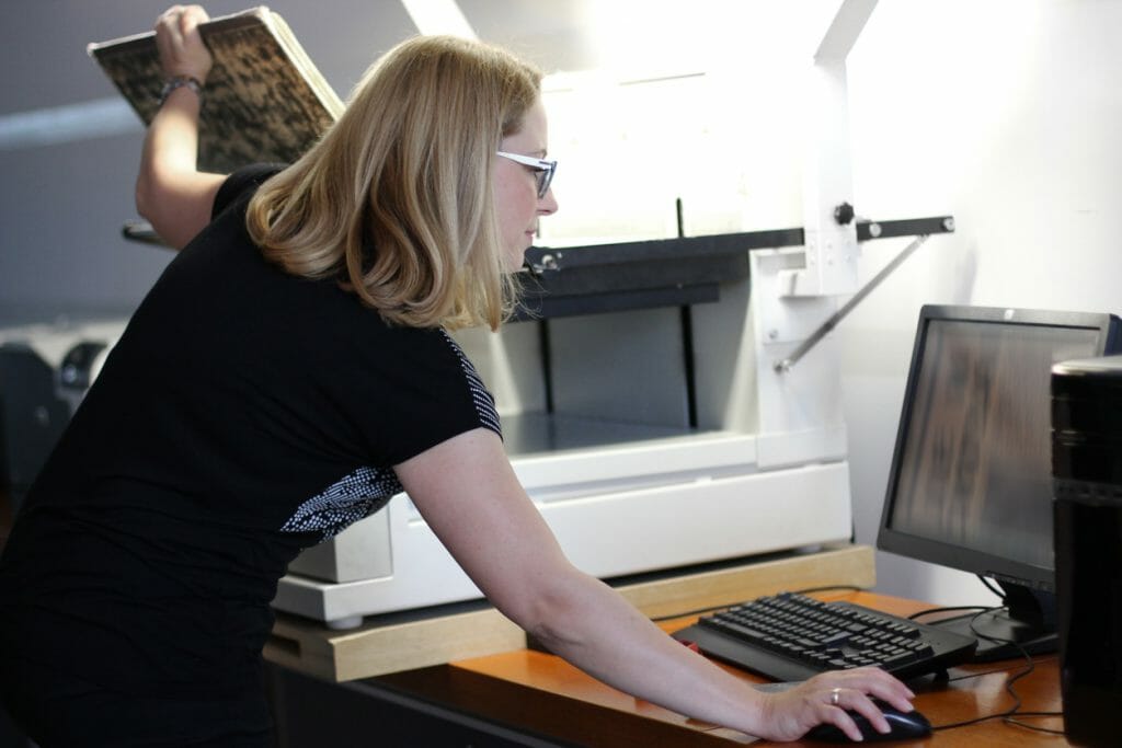 A woman scans and uploads documents to go paperless