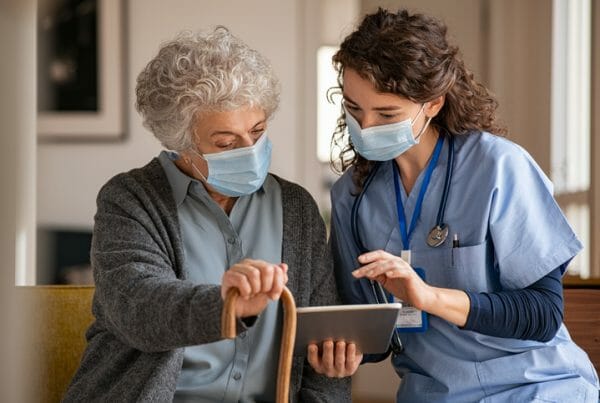 Emerging healthcare technology. A healthcare worker and an older woman look at a tablet together.